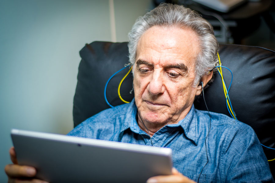 Neurofeedback for Seniors | Brain Training & Cognitive Wellness Elderly man using NeurOptimal® neurofeedback for cognitive support and relaxation in a therapy session.