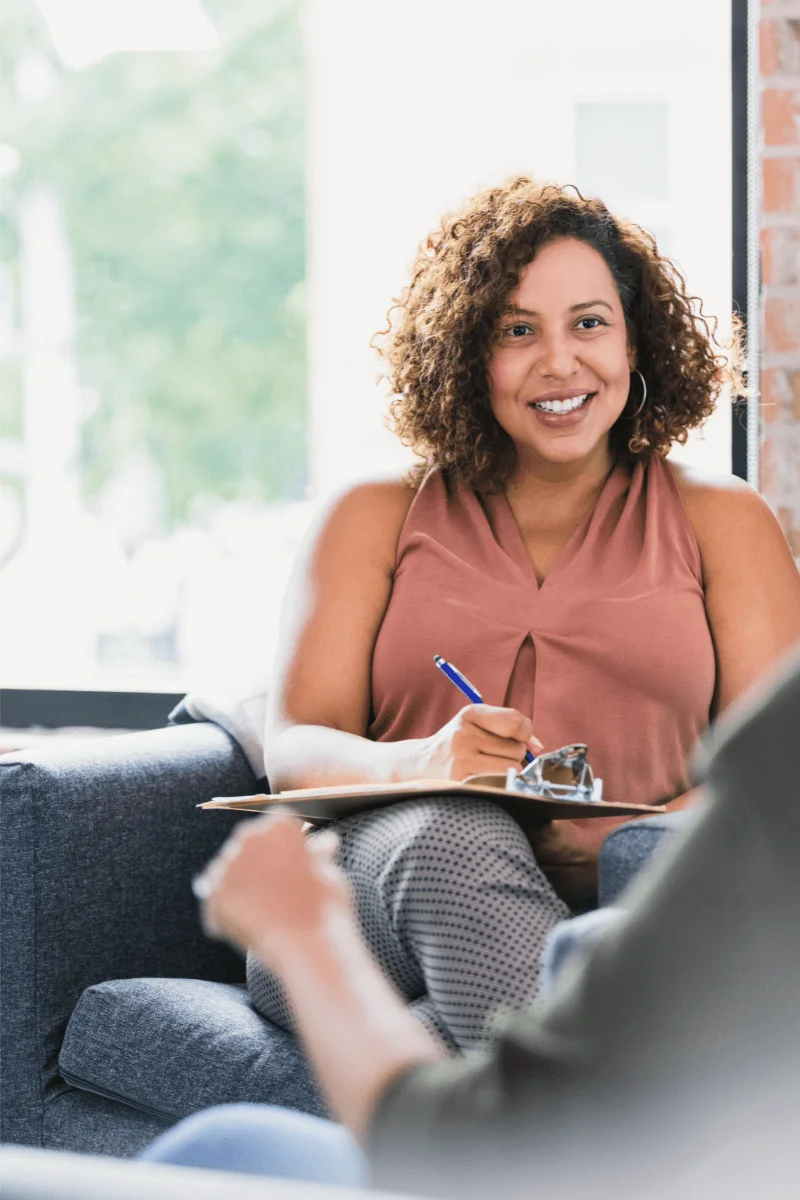Smiling therapist during a co-parenting counseling session, helping parents improve communication and collaboration.