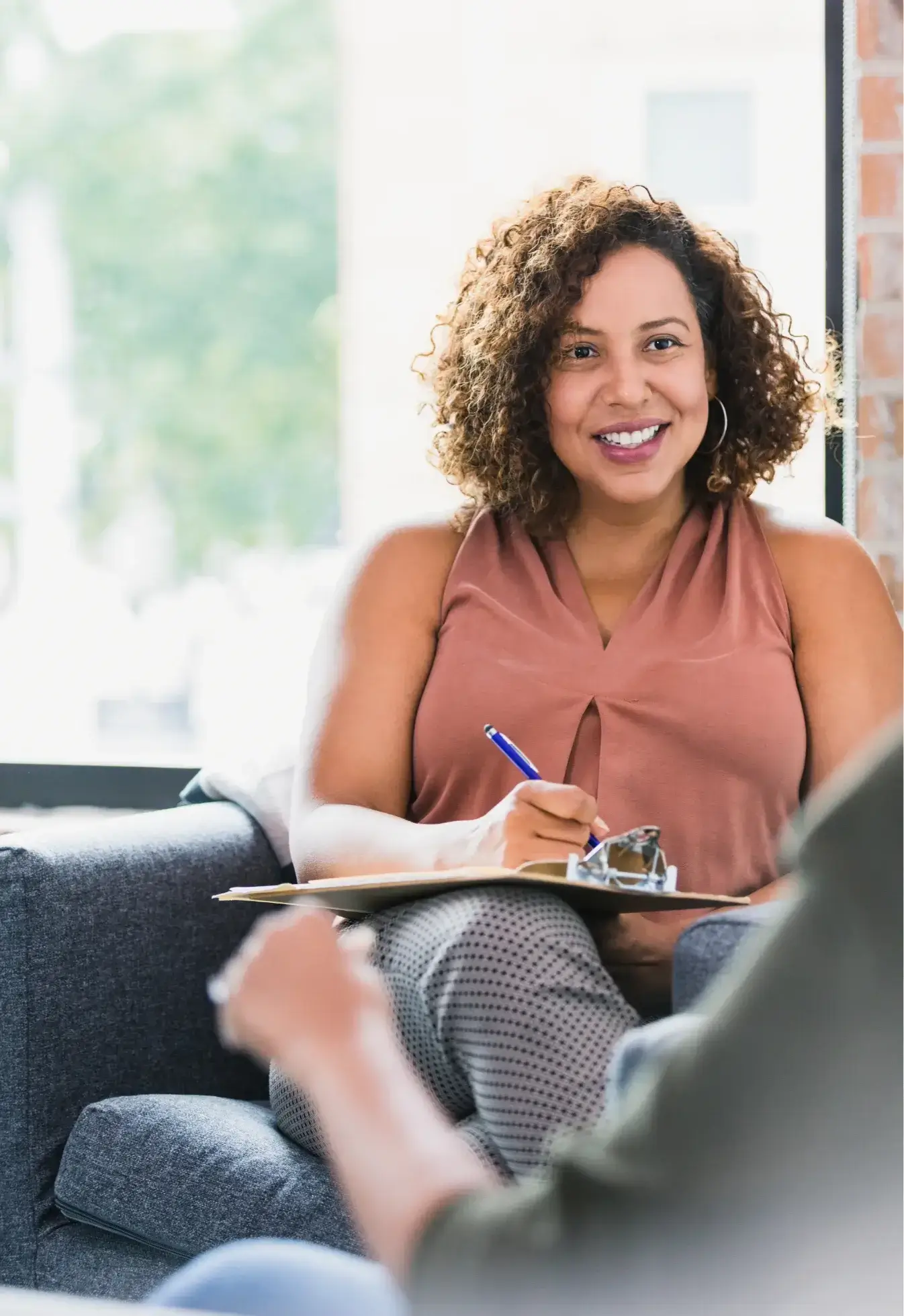 Smiling therapist during a co-parenting counseling session, helping parents improve communication and collaboration.
