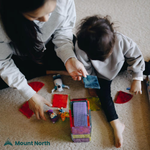 Mother and child playing with colorful educational toys on carpet